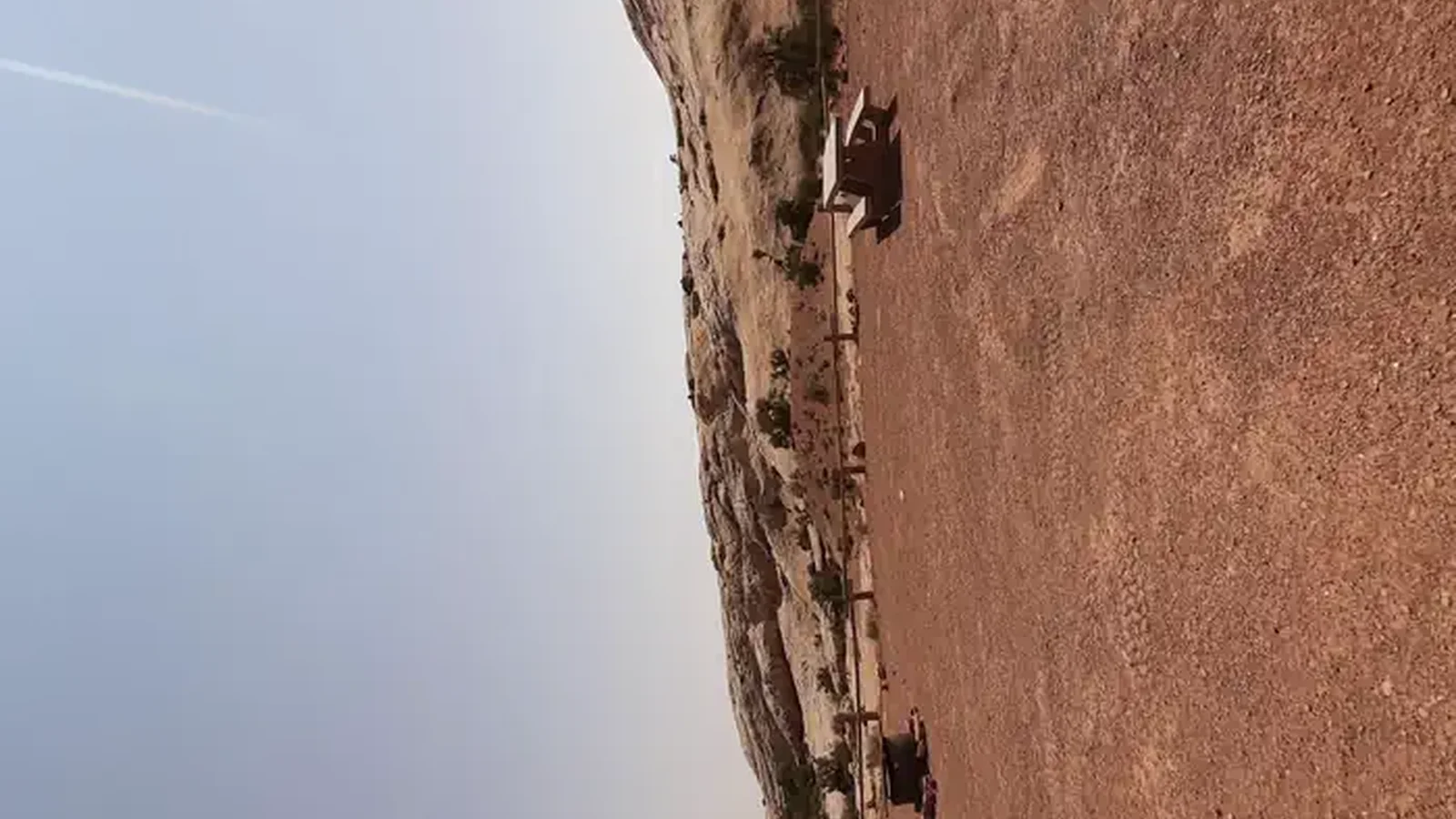 A primitive campsite on gravel ground with a fire ring and picnic table.