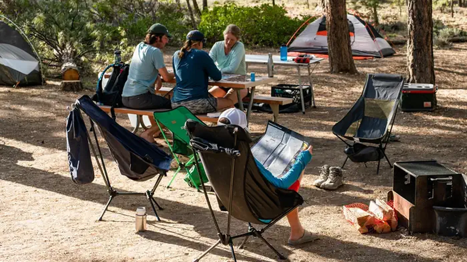 Tent campers relax at a picnic table at Sunset Campground