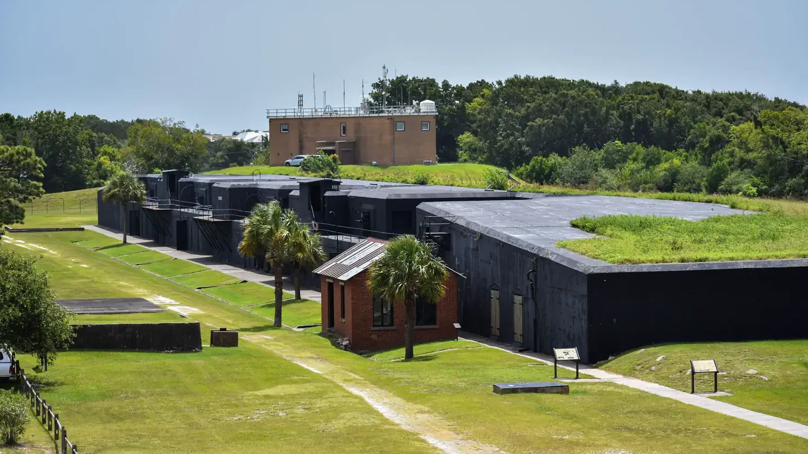View of Battery Jasper from an overlook at Fort Moultrie. The batteries walls are black and surrounded by a green grass lawn and roof.