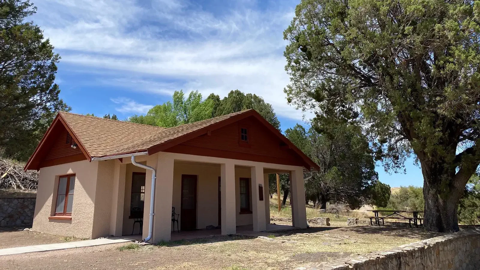 1930's era bungalow with a mature juniper tree off from the northeast corner of the porch