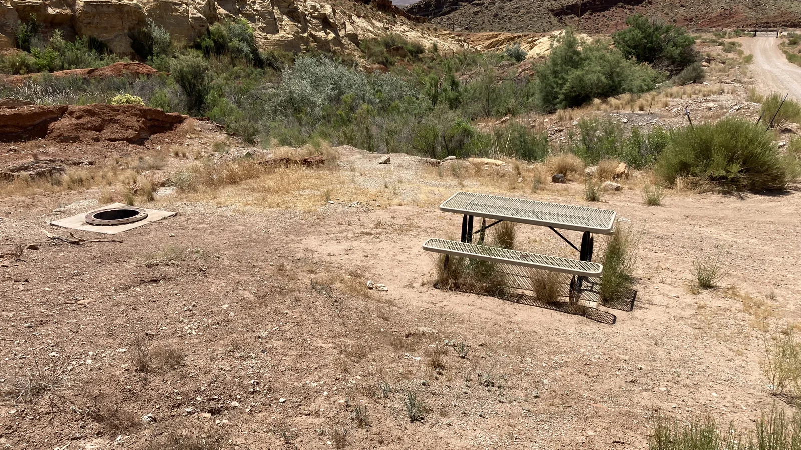 Flat, gravel campsite with a desert wash full at Quail Creek Reservoir Designated Dispersed Camping Area