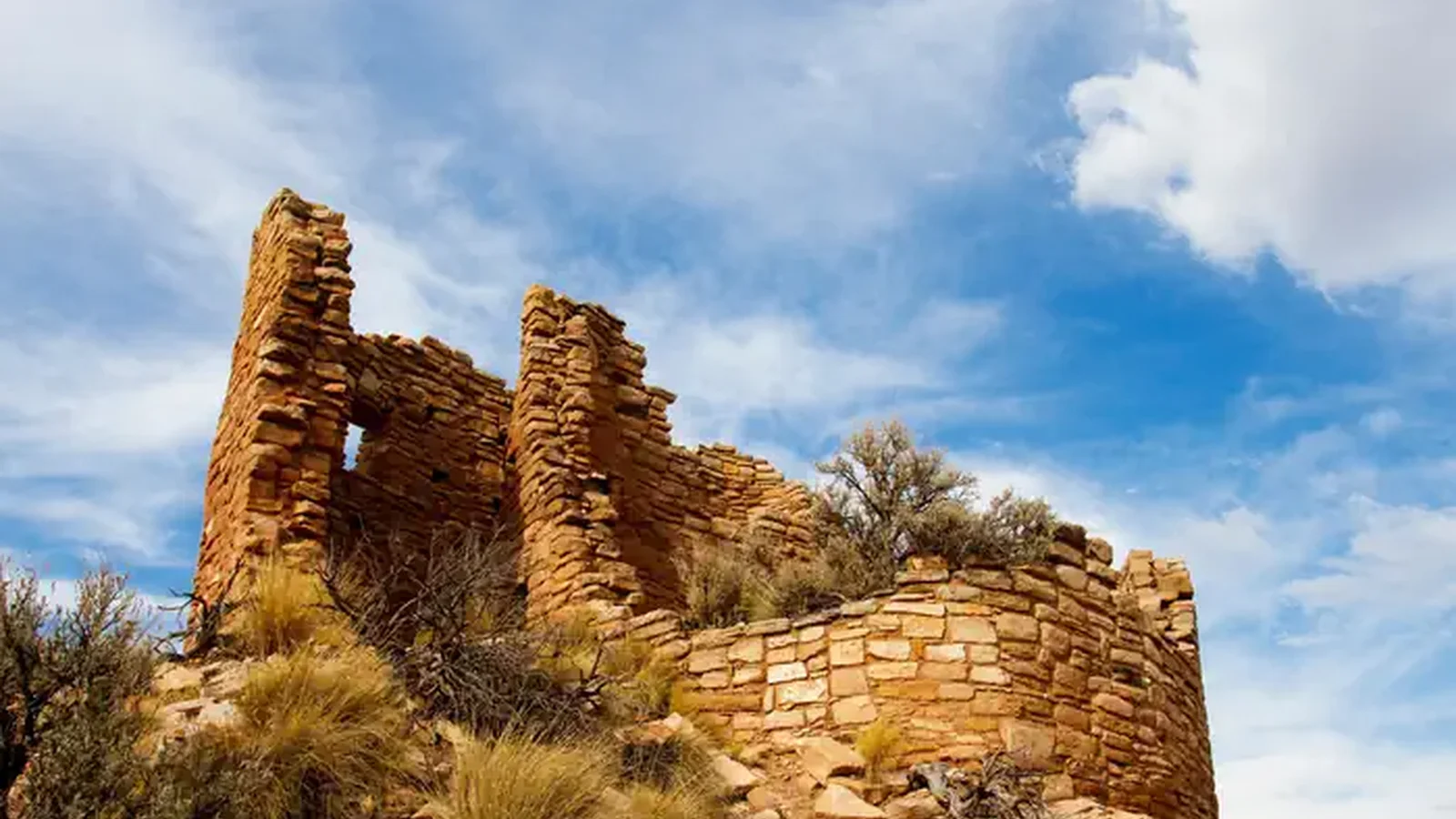 An ancient masonry structure under a bright blue sky
