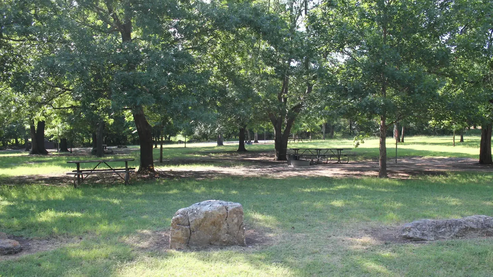 Central Group Campground showing picnic table, rocks, trees and grass.