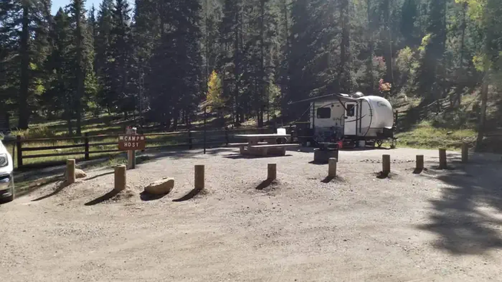 A camper occupies the host site at Panchulea with pines in the background.