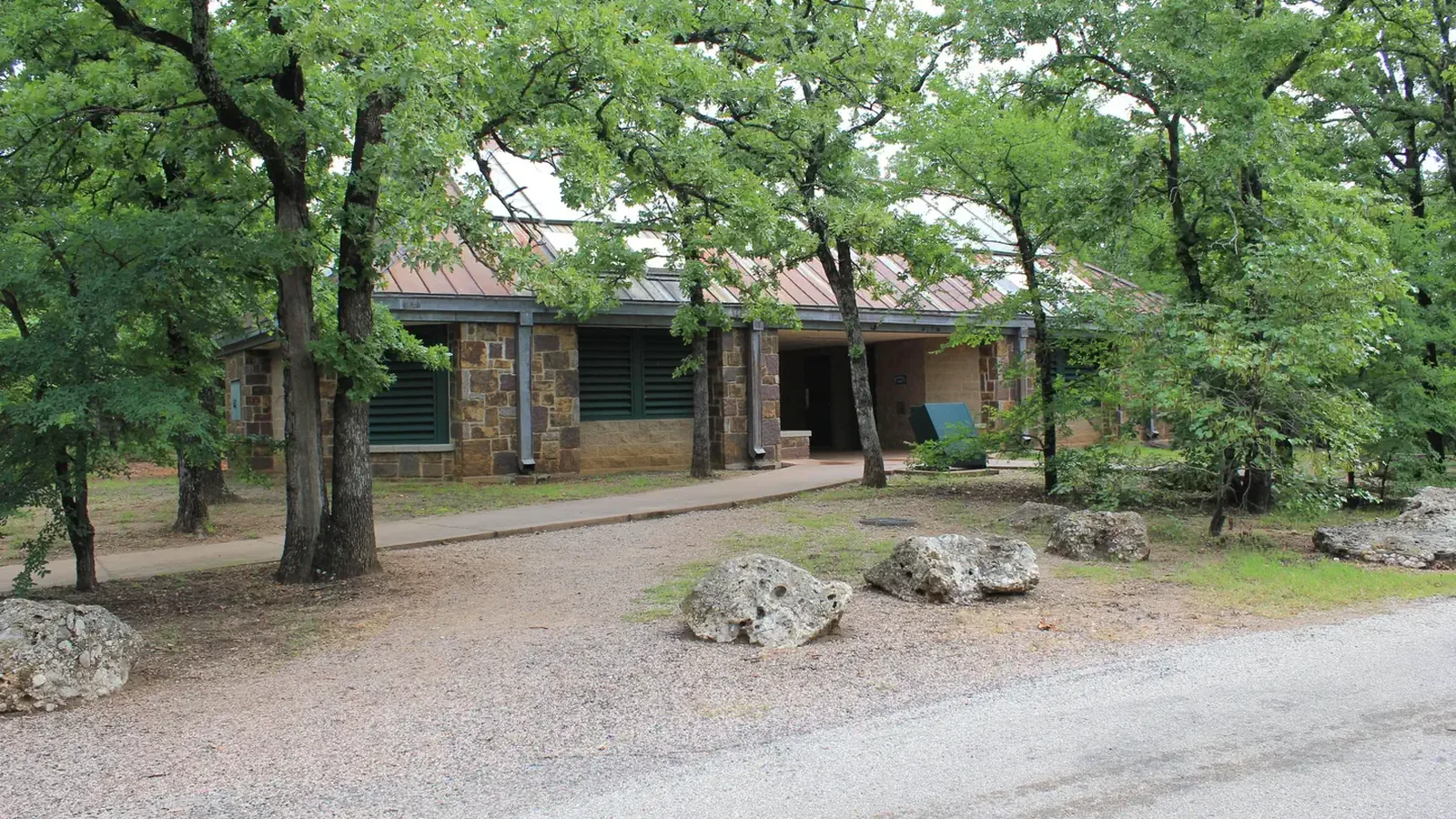 Brick building left of roadway in D Loop surrounded by trees.