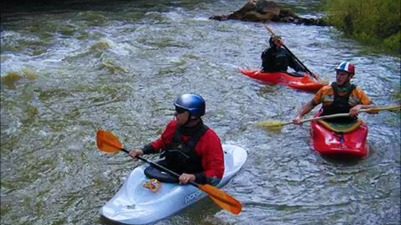 kayakers paddling swift water