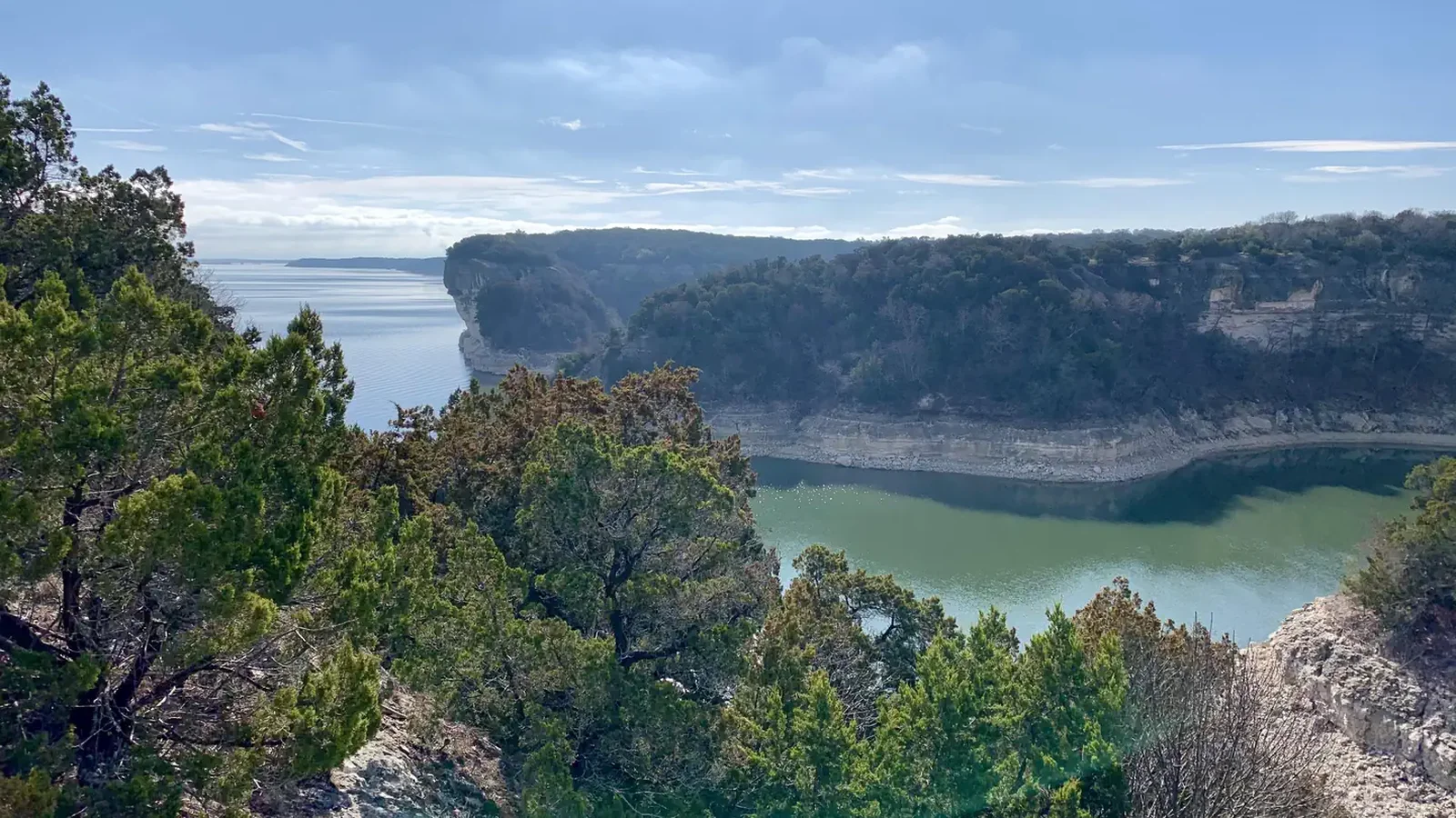 Limestone bluffs covered with ashe juniper trees surrounding Whitney Lake.