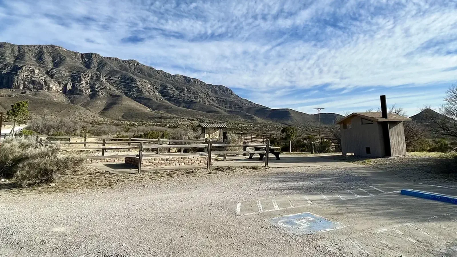 Frijole Horse Corral Campsite with RV parking spaces in the foreground, tent pads, picnic table and restroom are shown.