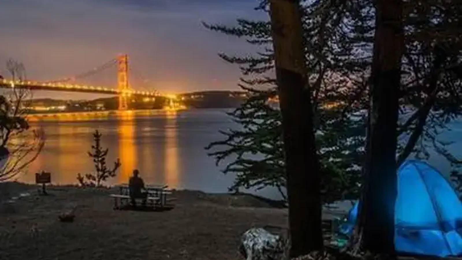 Kirby Cove at night, with the Golden Gate Bridge lit up across the bay.