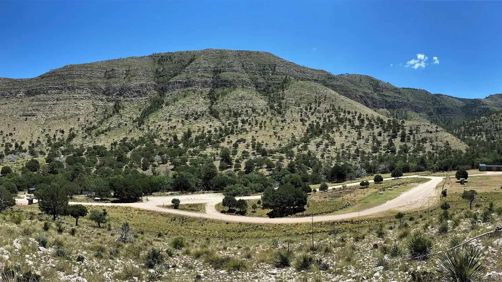 Overview of Dog Canyon campground and loop road with view of mountains in the background.