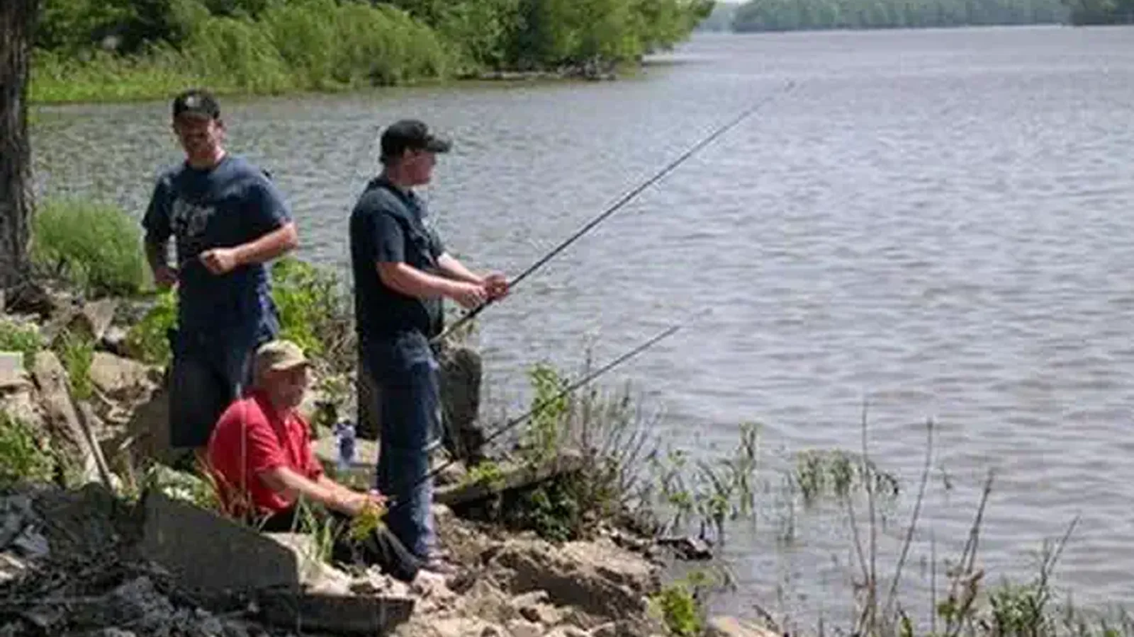 Three men fishing from shoreline.
