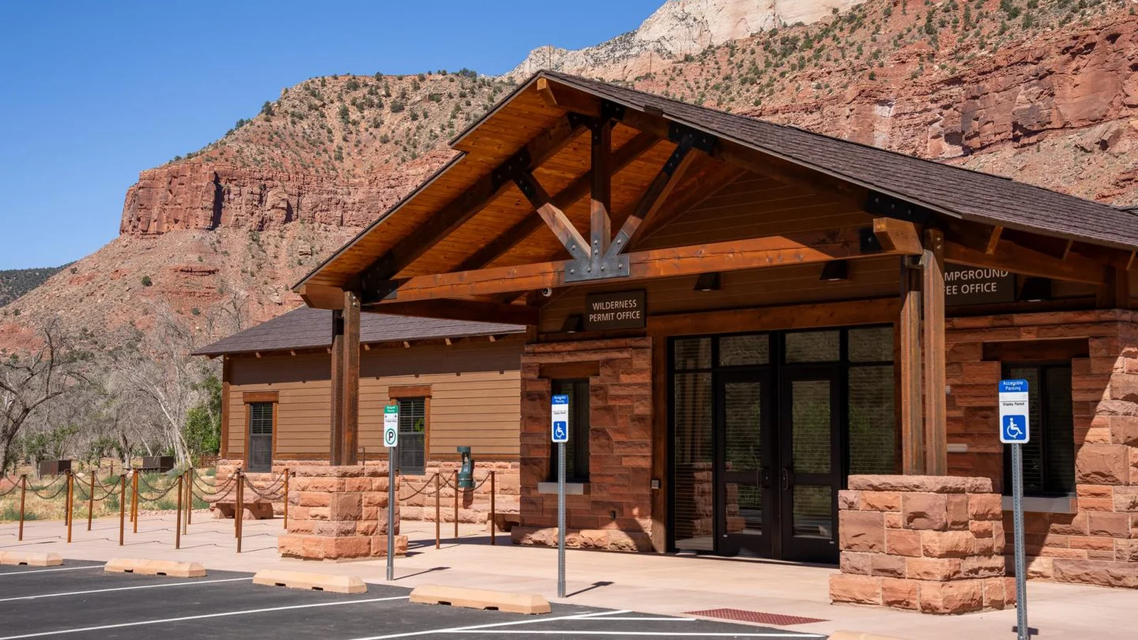 Campground reservation and wilderness permit office at South Campground in Zion National Park, with sandstone cliffs rising behind the building.