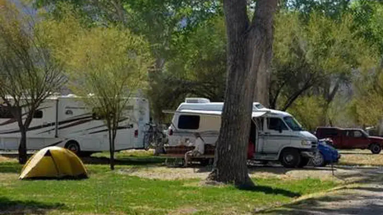 Travel trailer set up in the tree-lined campground