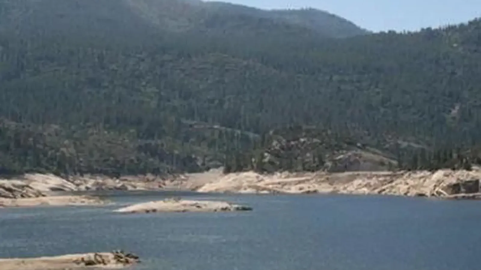 A shallow mountain lake on a blue sky day
