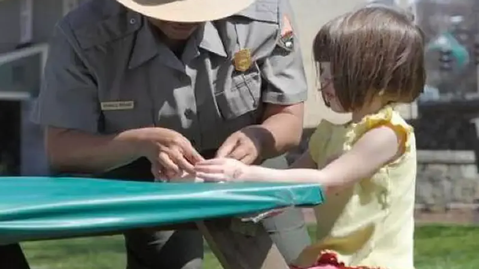 Ranger helping a child with an activity