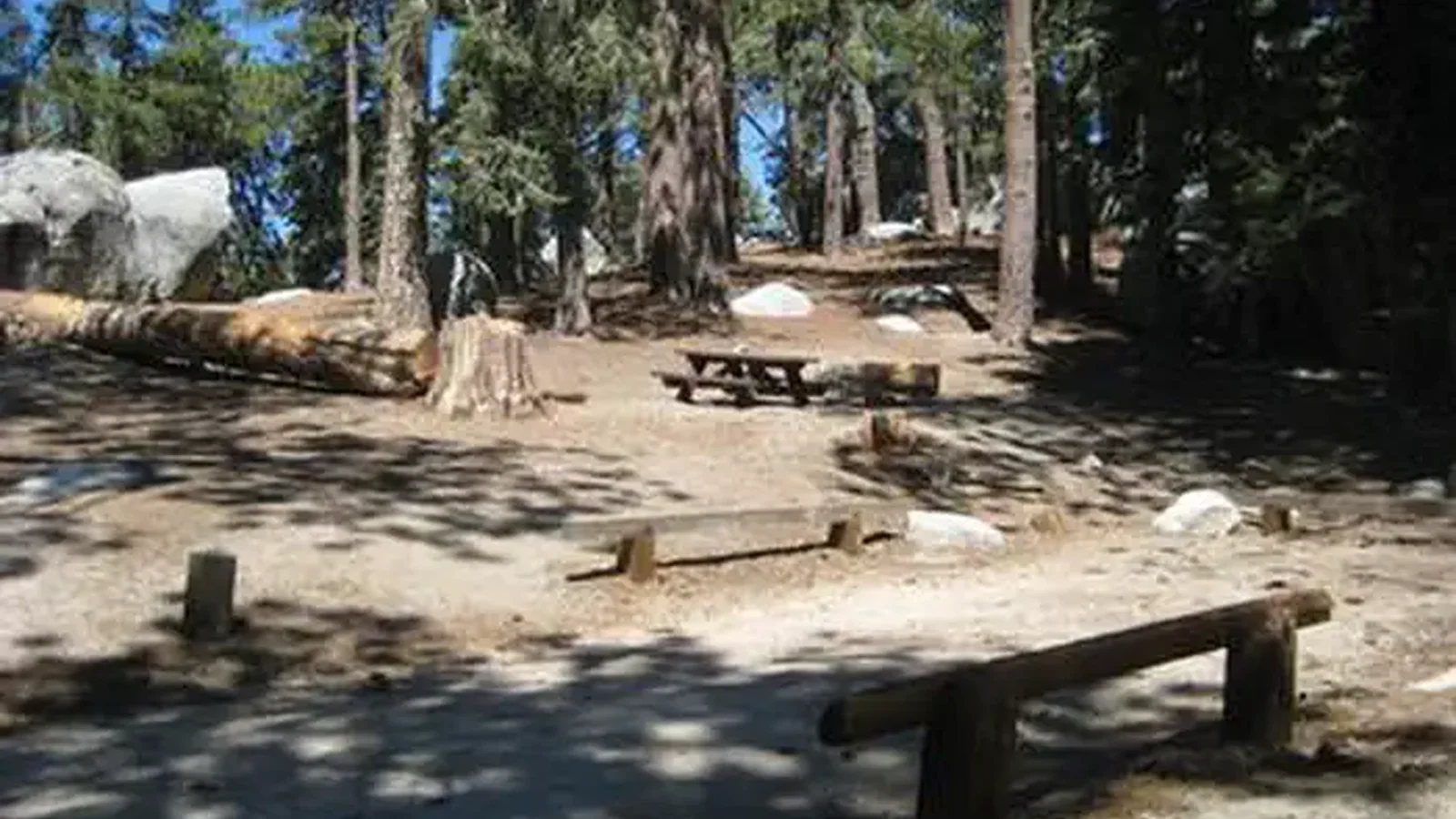 Campsite with picnic table and parking area.