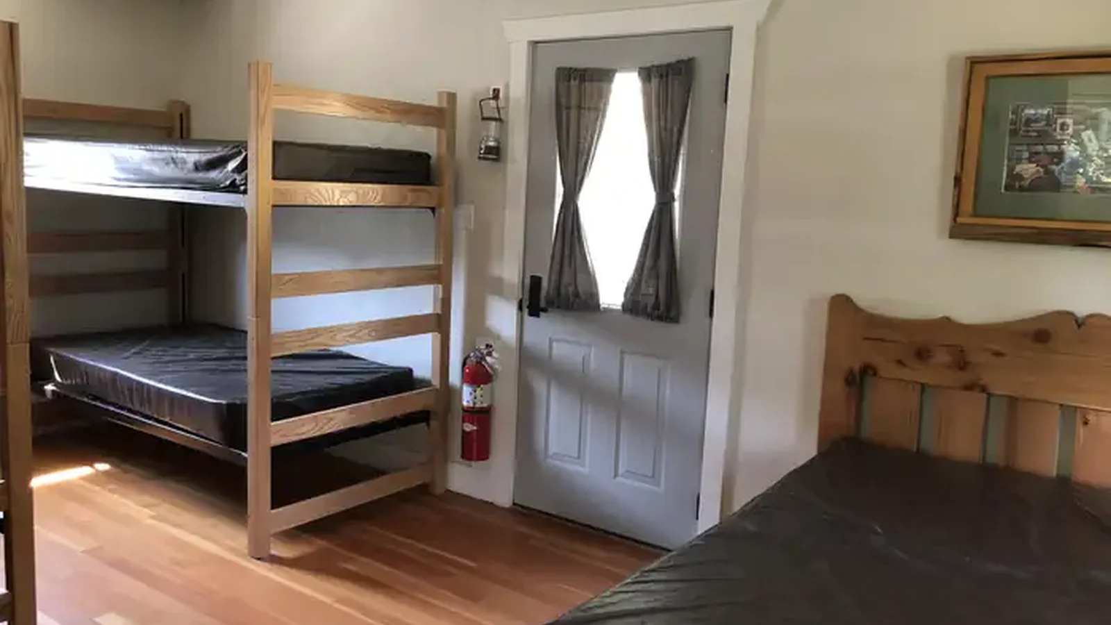 Bedroom is furnished with two sets of bunkbeds and one double bed.