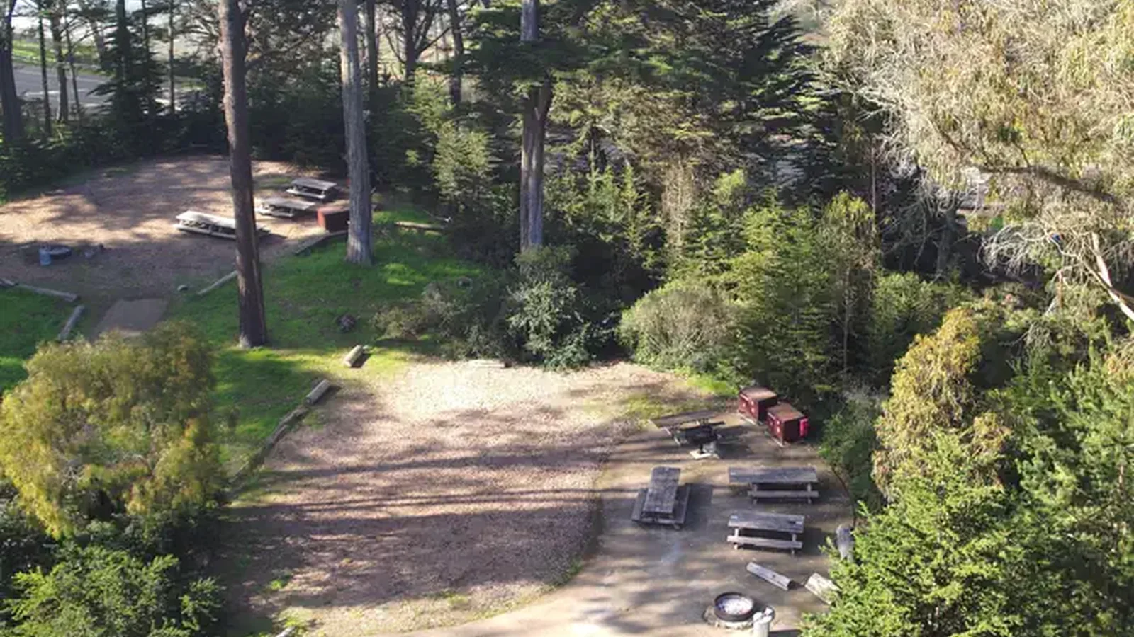 Two campsites surrounded by trees