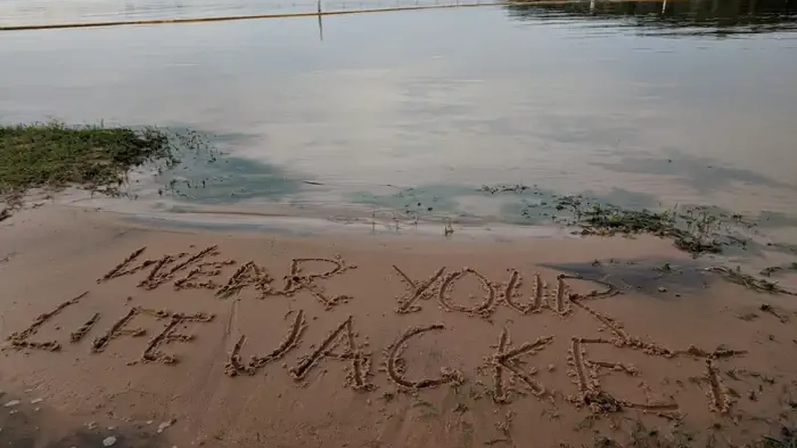"Wear Your Lifejacket" written in sand at Whitney Lake